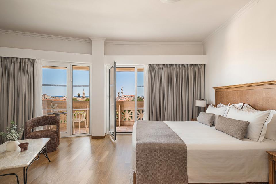 Junior Suite bedroom with king size bed and balcony doors framing the panoramic Old Town view